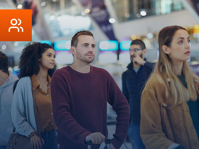 Passageiros em aeroporto sendo atendidos por agente aeroportuário